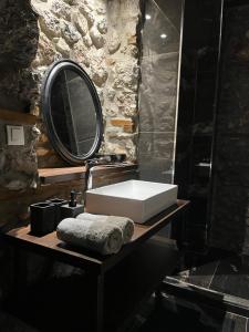 a bathroom with a sink and a mirror at Olympus Stone Lodge in Litochoro +14 photos