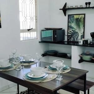 una mesa de madera con platos y copas de vino. en Casa central aconchegante, en Alto Paraíso de Goiás