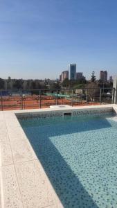 a large swimming pool with a city in the background at Departamento Tigre luminoso frente a club Acohaj in Tigre
