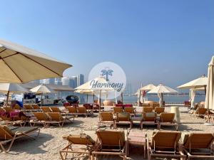 a group of chairs and umbrellas on a beach at Harmony Vacation Homes - South Residence in Dubai