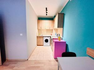Una cocina con un refrigerador rosa y un lavavajillas blanco. en Barbie Studio, en Sofía
