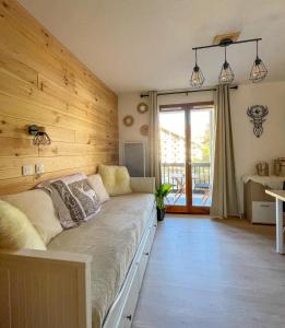 1 dormitorio con 1 cama con pared de madera en Chalereux studio a la montagne, en Auron