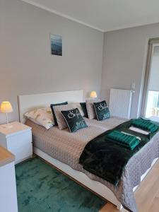 1 dormitorio con 1 cama grande con almohadas verdes en Rubus 305 Sofii en Świnoujście