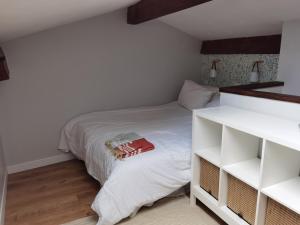 una piccola camera con letto bianco e scaffali bianchi di La maison margalaise a Margaux