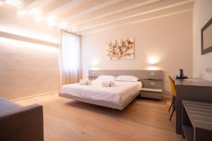sypialnia z białym łóżkiem i biurkiem w obiekcie Maison Calcirelli rooms w Weronie