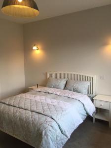 a bedroom with a large bed with a white comforter at The Plain View in Boyle