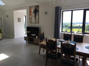 a living room with a dining room table and a television at The Plain View in Boyle