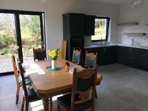 eine Küche mit einem Holztisch mit Stühlen und einem Esszimmer in der Unterkunft The Plain View in Boyle