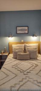 a bedroom with a large bed with a blue wall at La Perle de l'Océan, à deux pas de la mer sans route à traverser, parking privé, piscine in Arzon