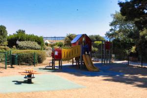 a playground with a slide in a park at La Perle de l'Océan, à deux pas de la mer sans route à traverser, parking privé, piscine in Arzon