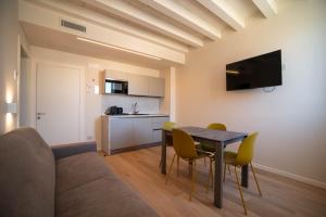 a living room with a table and chairs and a kitchen at Calcirelli Suites in Verona