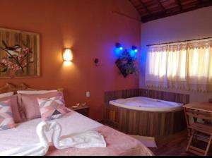 a bedroom with a bath tub and a bed at Pousada recanto Lajinha maua in Resende
