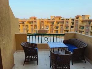 a balcony with a table and chairs and buildings at متاح للايجار للعائلات فقط! شاليه بقرية اورلاندو 1بالعين السخنة For families only !cozy chalet in orlando 1 Ain El sokhna in Ain Sokhna