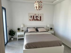 Appartement Costa Mar Martil-Tetouan في مرتيل: غرفة نوم بسرير وليلتين