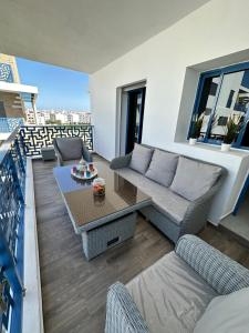 Appartement Costa Mar Martil-Tetouan في مرتيل: غرفة معيشة مع أريكة وطاولة على شرفة