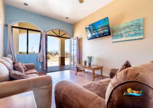 a living room with two couches and a tv at Family resort home pools tennis shady beach and family golfing in San Felipe +17 photos