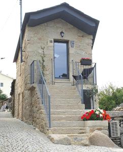 ein kleines Steingebäude mit einer Treppe und einer Tür in der Unterkunft Casa Fina in São Pedro do Sul