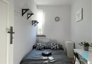 ein kleines Schlafzimmer mit einem Bett und einem Tisch in der Unterkunft August Room in Danzig