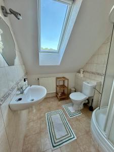 a bathroom with a sink and a toilet and a window at Apartmama Lipová in Lipova Lazne