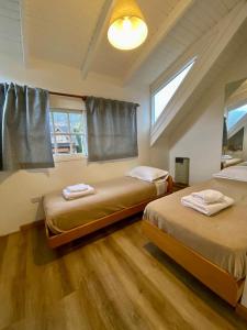 1 dormitorio con 2 camas y ventana en Casa Cipres en San Martín de los Andes