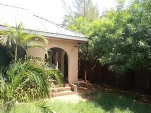 een klein huis met een veranda en enkele bomen bij Serene Modern 3 bedroom house near Mombasa Road in Emali