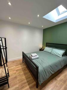 a bedroom with a large bed with a skylight at Dallas House - Easy links to LHR and London in Hayes