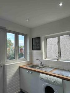 a kitchen with a sink and a washing machine at Dallas House - Easy links to LHR and London in Hayes