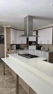 una gran cocina con una gran encimera blanca en RNB Guesthouse, en Roodepoort