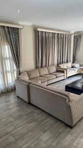 a living room with a couch and a table at RNB Guesthouse in Roodepoort