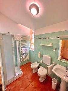 a bathroom with a toilet and a sink at Caroline Hotel in Brusimpiano