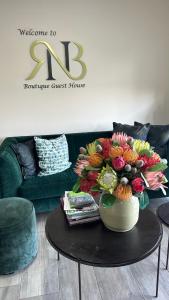RNB Guesthouse في روديبورت: إناء من الزهور على طاولة في غرفة المعيشة
