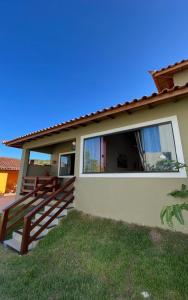 a house with a balcony and a yard at Sonia Flats - Chalé a 500 metros da Praia da Tartaruga in Búzios