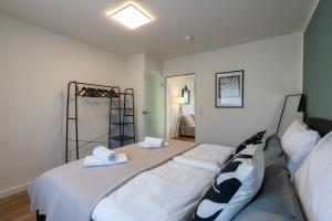 um quarto com uma cama grande e lençóis brancos em CARICASA Stylisches Apartment in der Nähe von Nürnberg em Schwarzenbruck