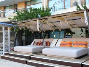two beds under an umbrella on some steps at Sunrise Studio Grenada in Sunny Beach