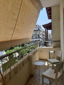 a balcony with two chairs and a table on a building at Retro comfy home near Monastiraki in Athens