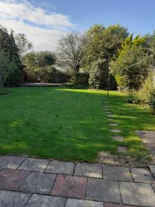 a large grassy yard with a stone pathway at silver way in Highcliffe