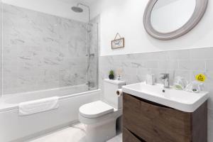 ein Badezimmer mit einem Waschbecken, einem WC und einer Badewanne in der Unterkunft Stylish & modern home across the road from the famous Penny Lane walking distance to cafes restaurants and supermarkets in Liverpool