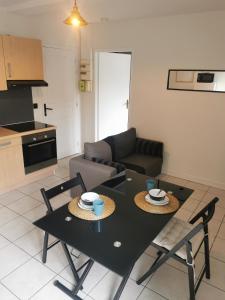 安锡Charmant appartement à 1 minute du lac的客厅里有一张黑色的桌子和椅子