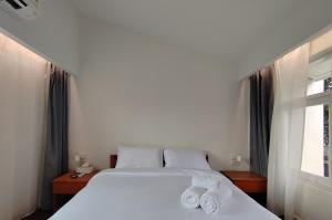 a bedroom with two white beds and a window at Sense of Haiya in Chiang Mai