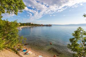 a group of people on a beach in the water at Apartment "CAROVO 7" in Kraljevica