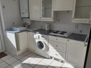 a white kitchen with a washing machine in it at silver way in Highcliffe