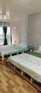 3 camas num quarto com pisos em madeira em H2 homestay phố cổ check in tự động em Hanói