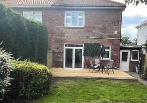 a house with a patio with a table and chairs at Modern Family home large garden free parking in Newcastle upon Tyne