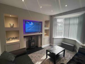 a living room with a flat screen tv and a fireplace at Modern Family home large garden free parking in Newcastle upon Tyne
