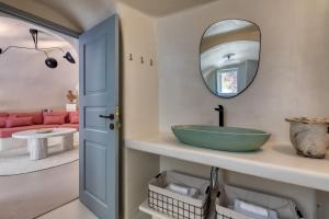 a bathroom with a green sink and a mirror at Hermes Cave House by Oias Local Cave Houses in Oia +6 photos