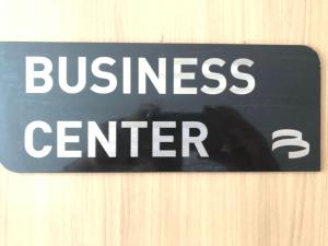 a sign for a business center on a wooden wall at Flat Versatti - Próximo Real Hospital Port e Pólo Médico Ilha do Leite in Recife