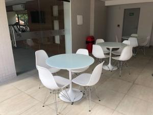 a group of tables and white chairs in a room at Flat Versatti - Próximo Real Hospital Port e Pólo Médico Ilha do Leite in Recife