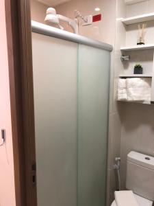 a bathroom with a glass shower door and a toilet at Flat Versatti - Próximo Real Hospital Port e Pólo Médico Ilha do Leite in Recife
