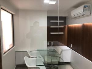 a glass table in a kitchen with two white chairs at Flat Versatti - Próximo Real Hospital Port e Pólo Médico Ilha do Leite in Recife