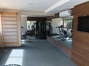 a room with a gym with tread machines and a television at Flat Versatti - Próximo Real Hospital Port e Pólo Médico Ilha do Leite in Recife